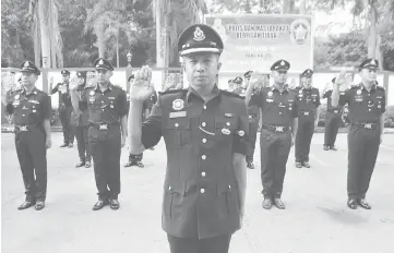  ??  ?? Parade commander Inspector Isan Sari leads the rank-and-file personnel in the oath-taking during the celebratio­n.