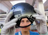  ??  ?? An employee inspects the cover of an axial fan on the assembly line in Mulfingen, Germany.