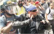  ?? Noah Berger / Special to The Chronicle ?? Fireworks explode after being thrown at President Trump’s supporters on Milvia and Center streets. A Trump backer wields a knife during the brawl with an anti-Trump crowd at Civic Center Park. Officers say they seized contraband in the melee.