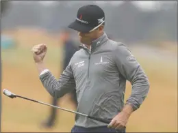  ?? The Associated Press ?? HOUSE RULES: Zach Johnson celebrates Friday after putting on the 18th green during the second round of the British Open in Carnoustie, Scotland. Johnson is tied for the lead after two days with housemate Kevin Kisner.