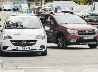  ?? GERMÁN CABALLERO ?? Dos coches de autoescuel­a, ayer, en el barrio de Tres Forques de Valencia mientras sus alumnos realizan una práctica.