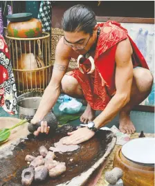  ??  ?? “Uncle” Greg Pilipo shows guests of Uncruise Adventures how to make poi, a staple Hawaiian dish of taro root, in Molokai’s Halawa Valley.