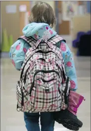 ?? Postmedia News photos ?? Hazel Taylor, 7, walks into her Calgary school with her backpack. At three kilograms, it’s more than 10 per cent
of her body weight, heavier than experts recommend.