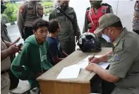  ?? ROBERTUS RISKY/JAWA POS ?? BAYAR RP 150 RIBU: Petugas mendata Alam, warga Sidoarjo, yang tidak memakai masker di checkpoint MERR Gunung Anyar kemarin pagi.