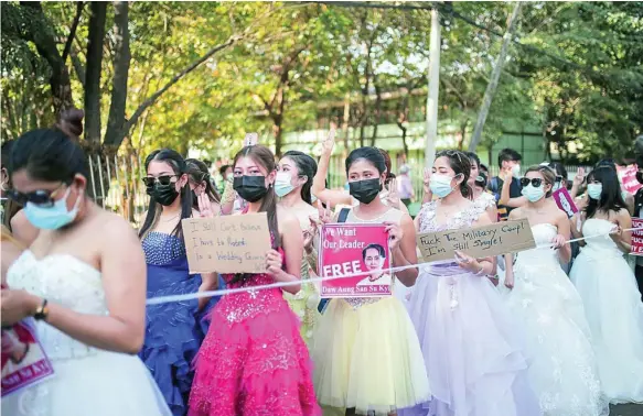  ?? REUTERS ?? Un grupo de manifestan­tes vestidas de princesas y con trajes de gala protestan, ayer, en Yangon contra el golpe y a favor de la libertad de Suu Kyi