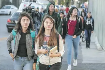  ?? Irfan Khan Los Angeles Times ?? STUDENTS arrive at Sal Castro Middle School on Friday. Police believe a 12-year-old girl brought a gun to the L.A. school that discharged from her backpack Thursday morning, firing a round that struck two teens.