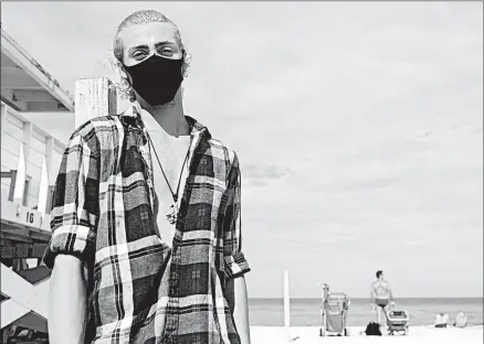  ?? LYNNE SLADKY/AP ?? Nivek Divincci wears a protective mask on the beach at Haulover Park in Miami.