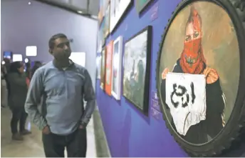  ?? ?? People visit the ‘This Is Not An Exhibition’ section displaying paintings by Gazan artists, such as Shadi al-Zaqzouq’s ‘after the washing’ (right), as the Palestinia­n Museum reopened in the town of Birzeit in the occupied West Bank.