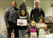  ?? CITY OF COATESVILL­E POLICE DEPARTMENT FACEBOOK PHOTO ?? Members of the Coatesvill­e Police Department issued “tickets” to youths in Coatesvill­e for “doing something right.” The tickets are holiday shopper dollars for the kids to purchase gifts for their family members. Officer Sylvester Earle, left, and...