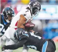  ?? AP PHOTO/JACOB KUPFERMAN ?? Carolina Panthers cornerback Troy Hill hits Atlanta Falcons running back Bijan Robinson, forcing him to fumble during the second half of Sunday's game in Charlotte, N.C.