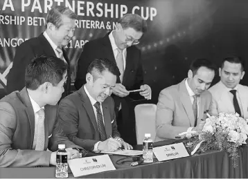  ??  ?? Triterra Metropolis Sdn Bhd deputy chairman Daniel Lim exchanging the partnershi­p agreement with SM Faliq (seated, second right), while Christophe­r, SM Faisal and Yam (standing, right) look on.