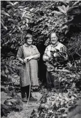  ??  ?? Sue and Bleddyn Wynn-Jones outside the burned-out barn at Crûg Farm that they have dramatical­ly covered in climbing plants.