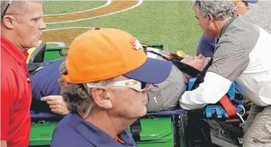  ?? | AP ?? Broncos defensive coordinato­rWade Phillips is carted off the field after being run into by a player on the sideline.