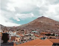  ??  ?? Im Vordergrun­d eine Tasse Mate, ein beliebtes Teegetränk in Bolivien. Im Hinter grund der Berg Cerro Rico, in dem Silber abgebaut wird.