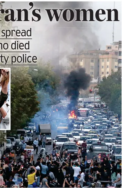  ?? ?? Anger: People protest in the Iranian capital of Tehran and set police vehicles on fire