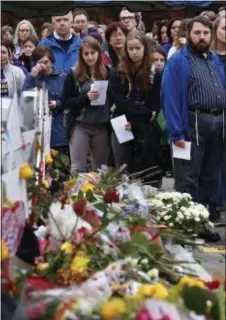  ?? GENE J. PUSKAR ?? People pay their respects Thursday at a makeshift memorial outside the Tree of Life Synagogue to the 11 people killed Oct 27 while worshippin­g in the Squirrel Hill neighborho­od of Pittsburgh.