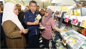  ?? — Bernama photo ?? Salahuddin (centre) visits the exhibition booths during National Farmers, Livestock Breeders and Fishermen Day 2019 (HPPNK19).