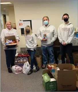  ?? SUBMITTED PHOTO ?? Generous team members at Brinker Simpson & Co., left to right, Kellie McShane-Harris, Lori Meehan, Bob Simpson and Jeff Hammons, collected food during Brinker Simpson’s November Food Drive. They are pictured getting ready to deliver the donations to Upper Darby Food Bank and Media Food Bank last week.