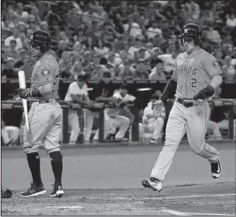  ?? The Associated Press ?? TROTTING HOME: Houston’s Alex Bregman (2) scores on a wild pitch by Arizona’s Anthony Banda as Jose Altuve, left, steps out of the way during the second inning of the Astros’ 9-4 victory Tuesday.