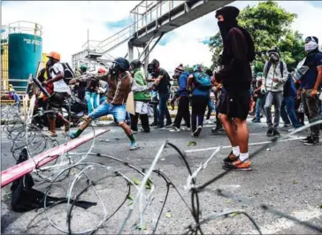  ?? RONALDO SCHEMIDT/AFP ?? Opposition activists clash with police during a march towards the Supreme Court of Justice in an offensive against President Maduro and his call for Constituen­t Assembly, in Caracas, on Saturday.