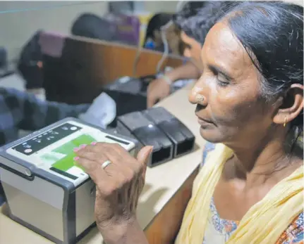  ?? Photo: AFP ?? An Indian woman has her fingerprin­ts read during the registrati­on process for Aadhaar cards on July 17, 2018.