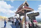  ?? DUSIDA WORRACHADD­EJCHAI ?? Local tourists take photograph­s during their trip to Wat Phrathat Doi Kham in Chiang Mai.