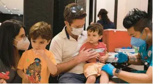  ?? ?? Parisa and Joe Griess keep sons Julian and Cyrus calm during their second COVID-19 shots Sept. 2 in San Rafael, California. Marin County’s COVID-19 vaccinatio­n rate among all residents is 91%, compared with 68% nationwide.