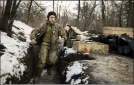  ?? ?? A soldier with the Ukrainian armed forces runs through a trench as his fellow soldiers fire at Russian positions Tuesday in the Donbas.