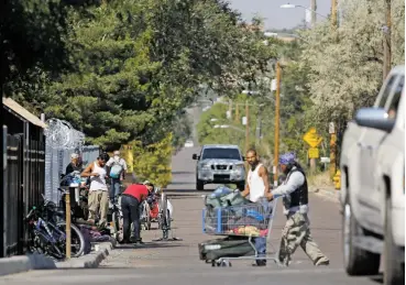  ?? PHOTOS BY LUIS SÁNCHEZ SATURNO THE NEW MEXICAN ?? People gather Monday outside the Interfaith Community Shelter at Pete’s Place. Concerns of neighborho­od residents have brought a commitment for $172,000 for lighting and sidewalk improvemen­ts on Harrison Road, plus increased police patrols.