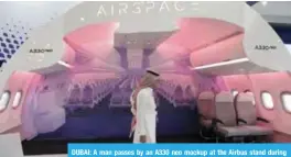  ??  ?? DUBAI: A man passes by an A330 neo mockup at the Airbus stand during the Airshow in Dubai yesterday. —AP