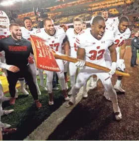  ?? SISTI/MILWAUKEE JOURNAL SENTINEL MIKE DE ?? Linebacker Leon Jacobs (right center) and the rest of the UW seniors helped the Badgers to a record 14th straight victory over Minnesota.