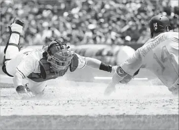  ?? John Minchillo Associated Press ?? ENRIQUE HERNANDEZ of the Dodgers is tagged out by Cincinnati catcher Tucker Barnhart while trying to score in the sixth inning on Joc Pederson’s fielder’s choice grounder to shortstop Arismendy Alcantara.