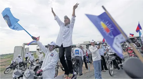  ??  ?? BUILDING MOMENTUM: Supporters of the Cambodia National Rescue Party shout as they gather during a local election campaign in Phnom Penh yesterday.