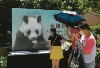  ?? KIN CHEUNG/AP ?? Visitors write notes to mourn the death of the oldest male giant panda in captivity Thursday at a theme park in Hong Kong. An An, who had been in deteriorat­ing health, was 35 years old or 105 in human years, the park said. An An and a female panda, Jia Jia, were gifted to Hong Kong by China in 1999. Jia Jia was the oldest panda in captivity when she died in 2016 at 38.