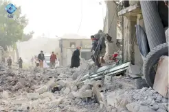  ??  ?? People inspect damage from airstrikes on a market on Monday in Atareb in the opposition-held countrysid­e outside Aleppo, Syria. (AP)