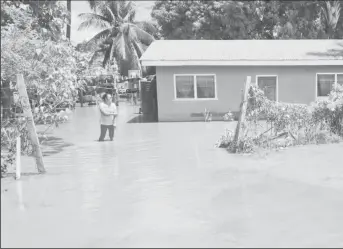  ?? ?? This woman stands in her yard showing how high the floodwater is (CDC photo)