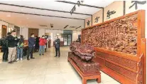  ?? PROVIDED TO CHINA DAILY ?? Foreign journalist­s are introduced to huge pieces of rosewood artwork at the East Rosewood Furniture Art Museum in Changshu.