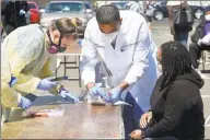  ?? Matthew Brown / Hearst Connecticu­t Media ?? Dr. Fawad Hameedi of DOCS Urgent Care Stamford administer­s a COVID- 19 nasal swab test on Lakeisha Thompson, 34, of Stamford, at a walk- up testing site for the coronaviru­s at AME Bethel Church in Stamford on May 2.