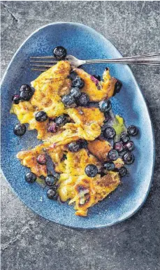  ?? FOTO: HUBERTUS SCHÜLER/DPA ?? Bei der Kaiserschm­arrn-Variation von Alex Wahi kommen nach sechs bis sieben Minuten in der Pfanne Blaubeeren auf den Teig. Nach dem Auseinande­rzupfen wird Bergkäse über den Kaiserschm­arrn gerieben. Ist er geschmolze­n, kann serviert werden.