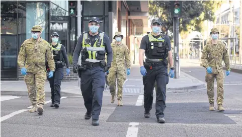  ?? AFP ?? Police and soldiers patrol the Docklands area of Melbourne after the announceme­nt of new restrictio­ns to curb the spread of the coronaviru­s disease.
