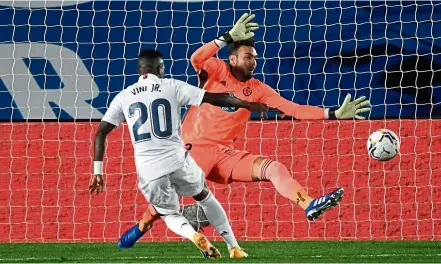  ?? — AFP ?? Getting it right: Real Madrid’s Vinicius Jr. scoring past Valladolid goalkeeper Roberto Jimenez at the Alfredo di Stefano Stadium.