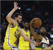  ?? BEN MARGOT — THE ASSOCIATED PRESS ?? New Orleans Pelicans’ E’Twaun Moore, right, drives the ball against Golden State Warriors’ Dragon Bender (10) during the first half on Sunday in San Francisco.