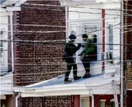  ?? JOE LAMBERTI/AFP VIA GETTY IMAGES ?? Police removed people from a home in Trenton, N.J., after reports that the shooting suspect was barricaded inside.