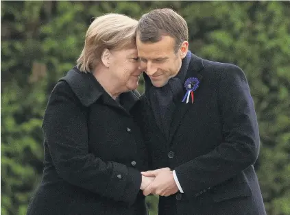  ?? PHOTO: REUTERS ?? Teteatete . . . French President Emmanuel Macron and German Chancellor Angela Merkel hug after unveiling a plaque in the Clairiere of Rethondes during a commemorat­ion ceremony for Armistice Day, 100 years after the end of World War 1, in Compiegne, France yesterday.