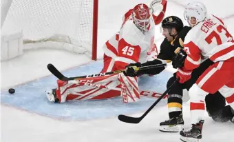  ?? CHRIS CHRISTO / HERALD STAFF ?? OUT IN FRONT: Patrice Bergeron had a step on Red Wings left wing Adam Erne and slips the puck past Jonathan Bernier for a short-handed goal in the second period that gave the Bruins a 2-1 lead Saturday afternoon.