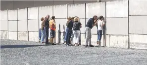  ?? GÜNTER STEFFEN, VISITBERLI­N ?? Narrow slits in barriers at the Berlin Wall Memorial provide glimpses of the “death strip,” where those fleeing East Berlin were often gunned down.