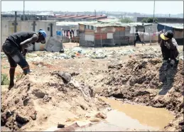  ??  ?? A child watches a zama zama at work in the Zamimpilo informal settlement on the edge of Johannesbu­rg.