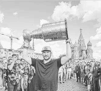  ?? JONATHAN NEWTON THE WASHINGTON POST ?? Washington Capitals captain Alex Ovechkin hoists the Stanley Cup in front of Saint Basil's Cathedral in Red Square. He toured his hometown with the National Hockey League’s title prize on the weekend.
