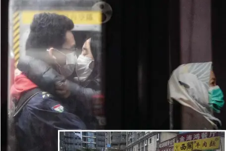  ?? GETTY IMAGES PHOTOS ?? CLOSE, BUT: A couple wearing face masks embraces Monday on a Hong Kong subway platform. Meanwhile, women in Wuhan, China, exercise as their city remains on lockdown for a fourth day.