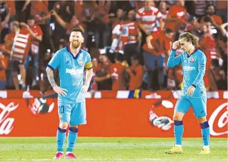  ?? AP-Yonhap ?? Barcelona’s Messi, left, and Antoine Griezmann react during the Spanish La Liga soccer match between Barcelona and Granada at the Los Carmenes stadium in Granada, Granada won 2-0.